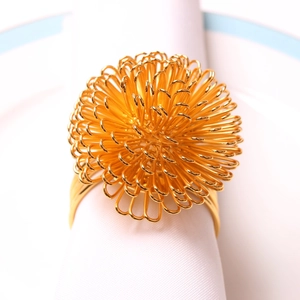 Elegant gold bayberry ball napkin ring with wire loops on white napkin and ceramic plate