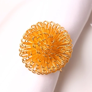 Macro detail of golden wire woven berry ball napkin ring on elegant white linen fabric