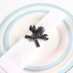 Gros plan du rond de serviette main de squelette noir sur une assiette blanche pour Halloween