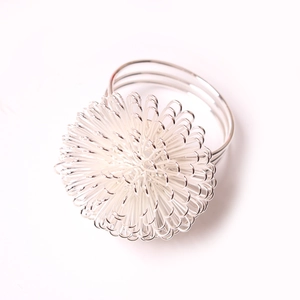Close-up of silver wire bayberry ball napkin ring with triple-loop metal base