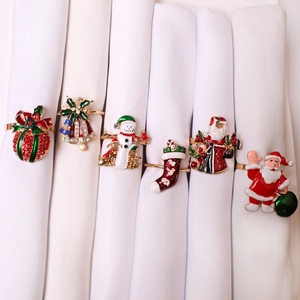 Christmas napkin ring set featuring Santa, snowman, and snowflake designs with gold finish