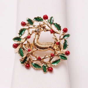 Detailed close-up of a Christmas reindeer napkin ring with green leaves and red berries