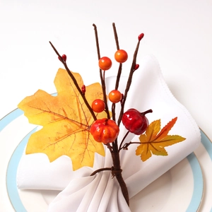 Rond de serviette automnal avec mini citrouilles, feuilles d'érable et baies rouges