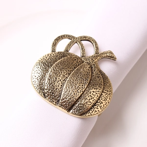 Detail of vintage gold pumpkin napkin ring with textured concave dot pattern on white cloth