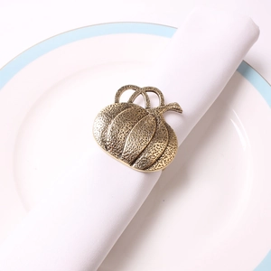 Detail of pumpkin napkin ring with hammered texture in bronze on white napkin