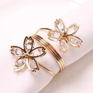 Close-up of cherry blossom napkin rings with gold finish and sparkling crystal details
