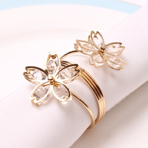 Detailed view of golden double cherry blossom napkin ring with crystal petals and spring band