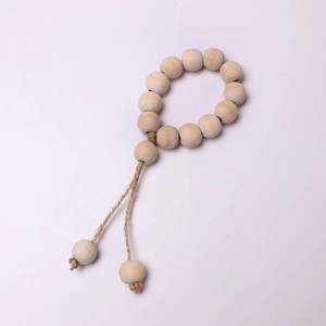 Detail of wooden bead napkin ring with jute rope tassels and natural wood texture