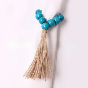 Close-up of bohemian peacock blue wooden bead napkin ring with natural jute fringe tassel