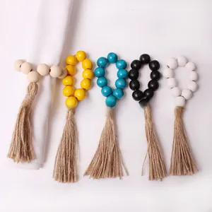 Detail of wooden bead napkin rings with jute tassels in five different natural colors