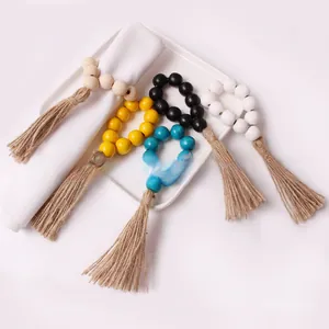 Detail of wooden bead napkin rings with jute tassels in various colors for table decor