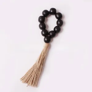 Close-up of black wooden bead napkin ring featuring a natural jute rope tassel detail