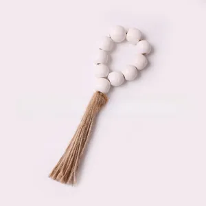 Close-up of white wooden bead napkin ring with a natural jute tassel for Christmas decor
