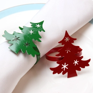 Detail of metal Christmas tree napkin rings with snowflake cutouts in red and green