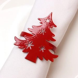 Close-up of red Christmas tree napkin ring with snowflake cutouts on white fabric