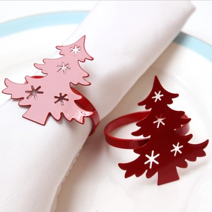 Christmas tree napkin rings with hollow snowflake patterns in pink and dark red metal