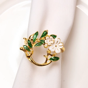 Gardenia flower napkin ring with gold leaves and white blossoms on dining table
