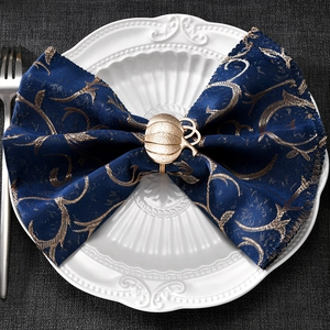 Macro view of golden pumpkin napkin ring with detailed texture on an embossed plate