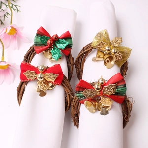 Detail shot of four Christmas napkin rings with red bows and golden bells on white napkins