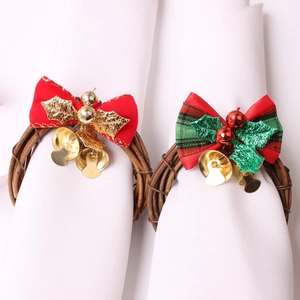 Christmas bow napkin rings with bells and holly leaves on natural rattan base
