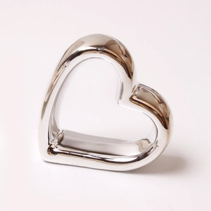Close-up of heart-shaped rose gold napkin ring with polished mirror finish for table decor