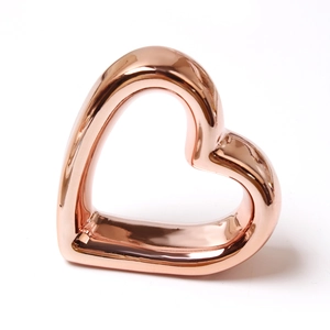 Macro detail of glossy rose gold heart napkin ring with reflective metallic finish