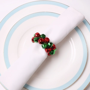 Détail du rond de serviette festif avec clochettes rouges et vertes sur assiette