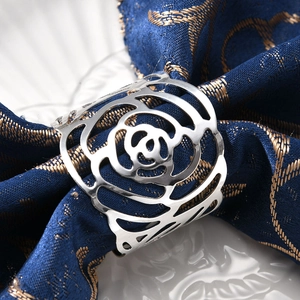 Elegant silver hollow rose napkin ring on a blue fabric napkin for formal table settings