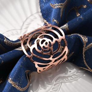 Elegant rose gold hollow flower napkin ring on navy blue cloth for table decoration