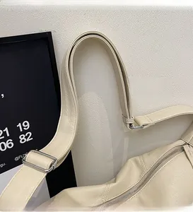 Close-up of adjustable strap with silver buckle on beige pebbled faux leather bag