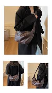 Detail view of large dark brown leather hobo bag with wide strap for daily commute
