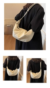 Detail view of cream dumpling bag featuring soft pleated leather and adjustable strap