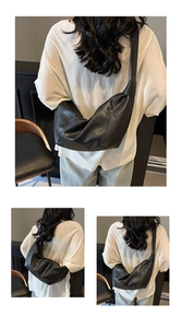 Detail of black pleated crossbody bag featuring a soft half-moon shape and knotted strap