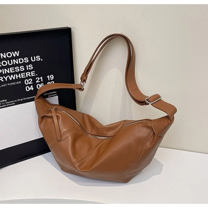 Detailed view of the brown leather half-moon bag with adjustable silver metal buckle