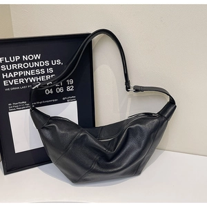 Detail of the black crescent bag showing segmented stitching and smooth vegan leather
