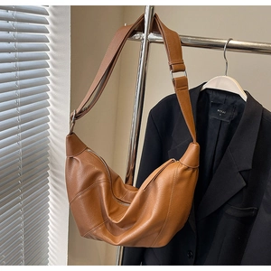 Detail view of caramel brown half-moon crossbody bag with soft PU leather and adjustable strap