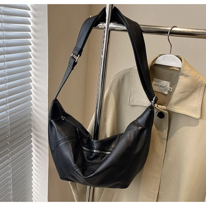 Detail of black large capacity crescent bag with soft textured leather and silver zipper