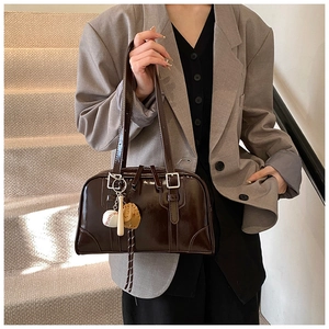 Detail of dark brown glossy tote bag featuring a creative baseball theme charm