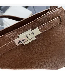 Close-up of caramel lychee grain leather and silver twist lock on a Kelly bag