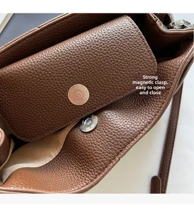 Detail of strong magnetic clasp and lychee pattern leather on brown shoulder bag