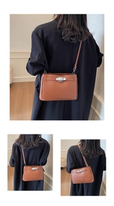 Detail of brown litchi pattern leather bag with iconic metal turn-lock and slim strap