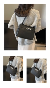 Close-up of black lychee grain leather handbag with silver metal turn-lock and strap