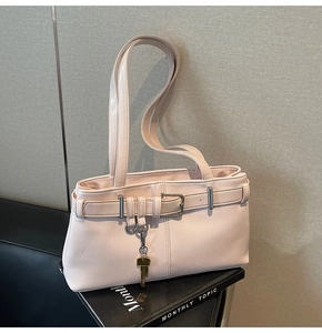 Detailed close-up of a pink soft leather underarm bag with silver buckle and gold key charm