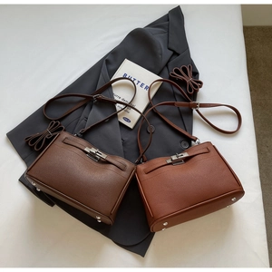 Detail of lychee pattern leather bags with turn-lock closure and metal bottom rivets