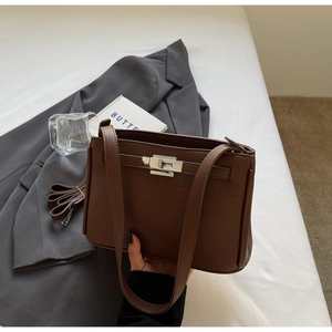 Detailed view of silver twist lock on dark brown lychee grain leather handbag
