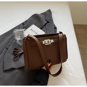 Detailed view of brown lychee grain leather handbag with silver metallic twist-lock