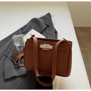 Detail of brown litchi pattern leather bag with silver metal swivel lock and strap