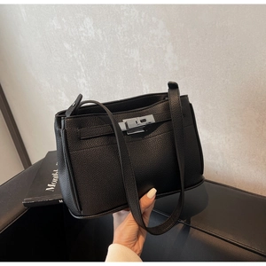 Detail of black lychee grain leather handbag with silver metallic twist lock closure
