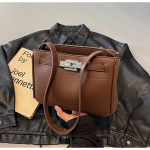 Detail of brown lychee grain leather shoulder bag with silver metal swivel lock