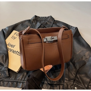 Detail of vintage brown pebble leather handbag with silver twist lock and strap